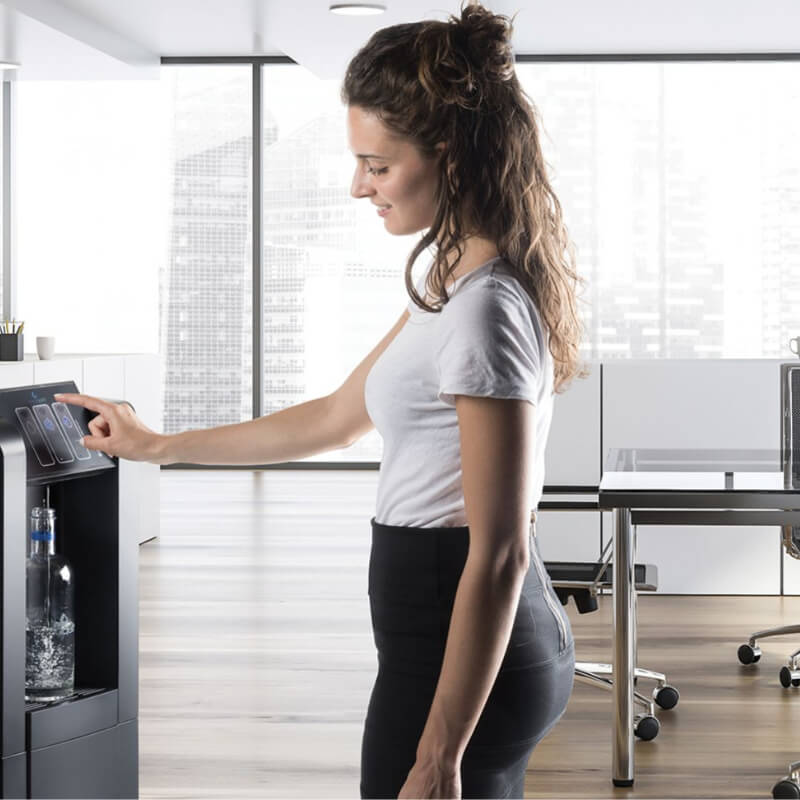 Wasserspender Büro - Frau zapft Wasser an Wasserspender